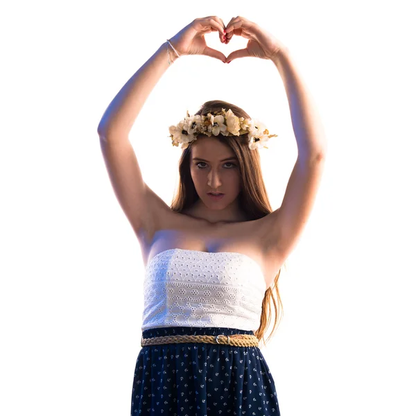 Meisje met kroon van bloemen maken van een hart met haar handen — Stockfoto