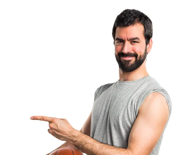 Człowiek, grając w koszykówkę, wskazując na boczne — Zdjęcie stockowe