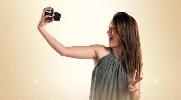 Chica joven sosteniendo una cámara — Foto de Stock