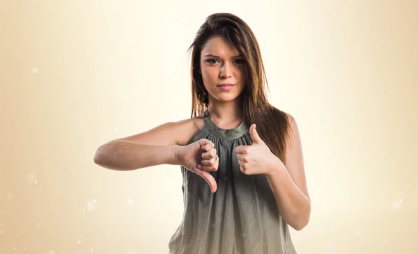 Young girl making good-bad sign — Stock Photo, Image