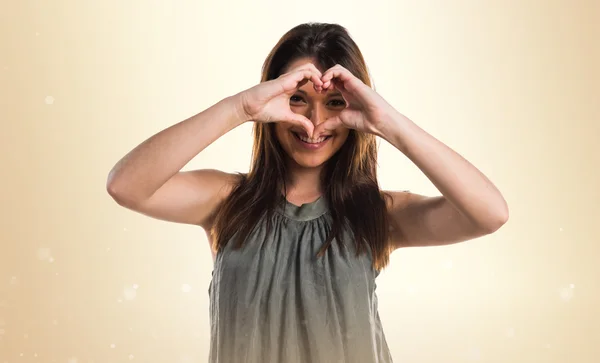 Young girl making a heart with her hands — Stock Photo, Image