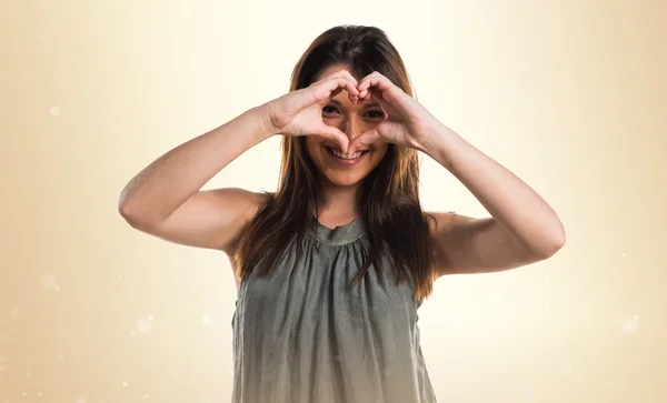 Chica joven haciendo un corazón con sus manos — Foto de Stock