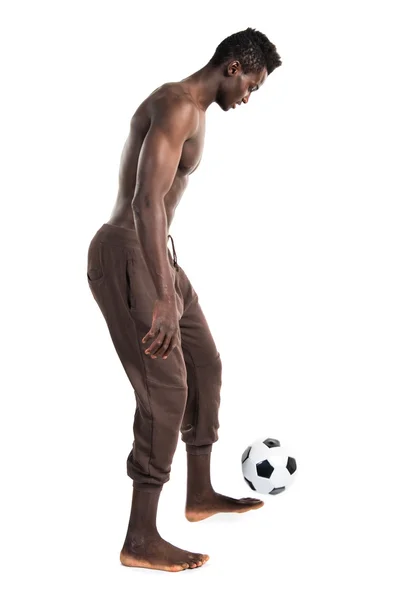 Чёрный человек играет в футбол — стоковое фото