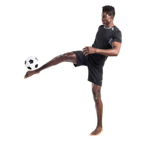 Чёрный человек играет в футбол — стоковое фото