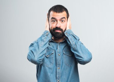 Adam kulaklarını kapatıyor.