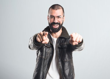 Öne doğru işaret eden bir deri ceket giyen adam