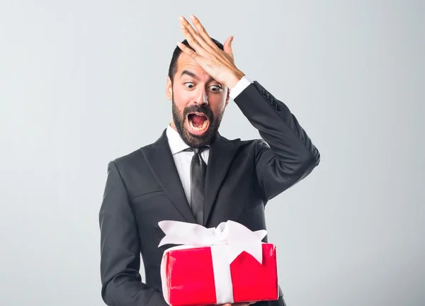 Zakenman houden een geschenk — Stockfoto