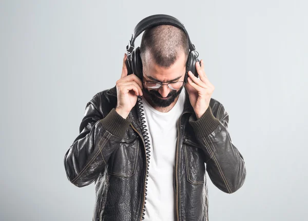 Человек в кожаной куртке слушает музыку — стоковое фото