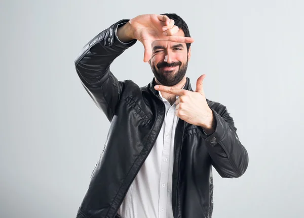 Hombre con chaqueta de cuero enfocándose con los dedos — Foto de Stock