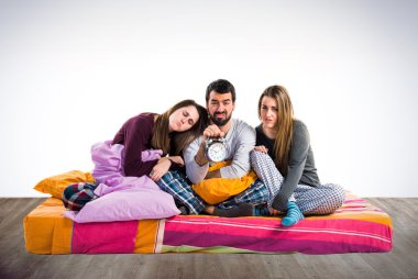 Vintage saat tutan bir yatakta üç arkadaş