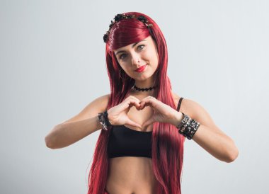 Genç Kızıl saçlı kız elleri ile bir kalp yapma