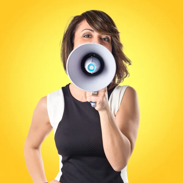 Pretty girl shouting with a megaphone over white background — Stock Photo, Image