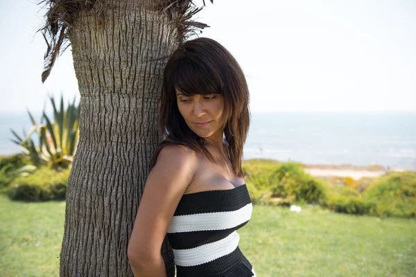 Hermosa mujer posando en un parque desde la playa — Foto de Stock