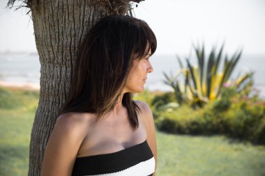 Güzel kadın bir parkta plaja poz