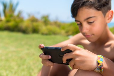 Cep telefonu kullanarak bir parkta çocuk