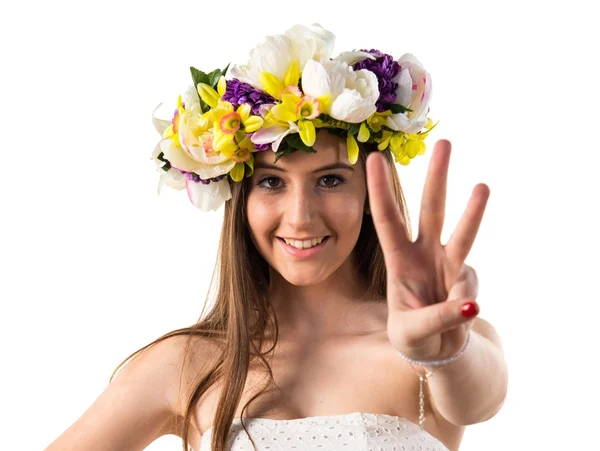 Menina com coroa de flores contando três — Fotografia de Stock