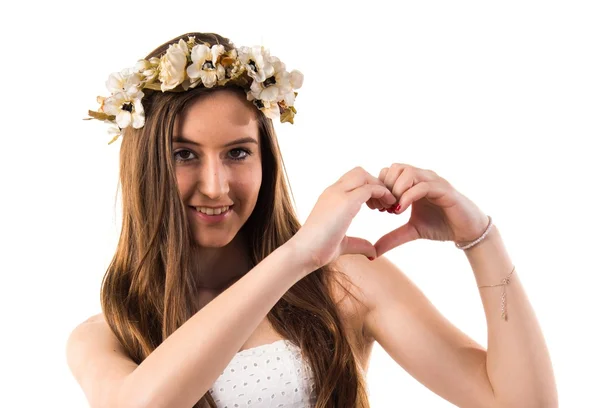 Girl with crown of flowers making a heart with her hands — Stock Photo, Image