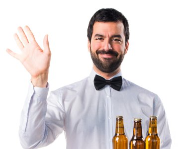 Garson tepsi selamlayan üzerinde bira şişeleri ile