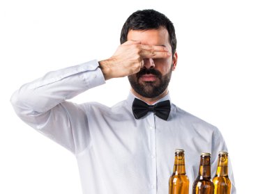 Garson bira şişeleri gözlerini kapsayan tepsi ile