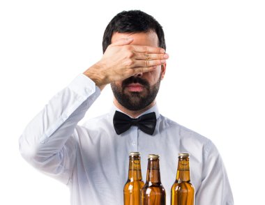 Garson bira şişeleri gözlerini kapsayan tepsi ile