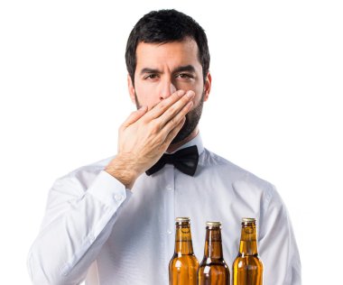 Garson ağzını kapsayan tepsi üzerinde bira şişeleri ile