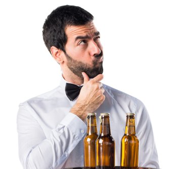 Garson tepsi düşünme üzerine bira şişeleri ile