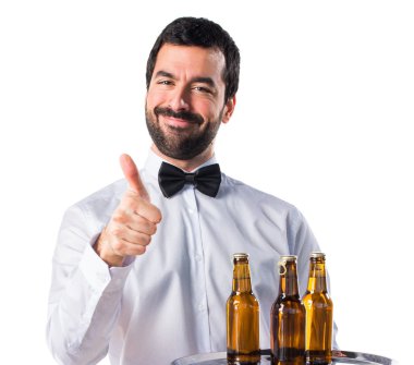 Garson bira şişeleri başparmak ile tepsi ile