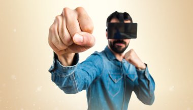 Bir yumruk vererek Vr gözlük kullanan adam