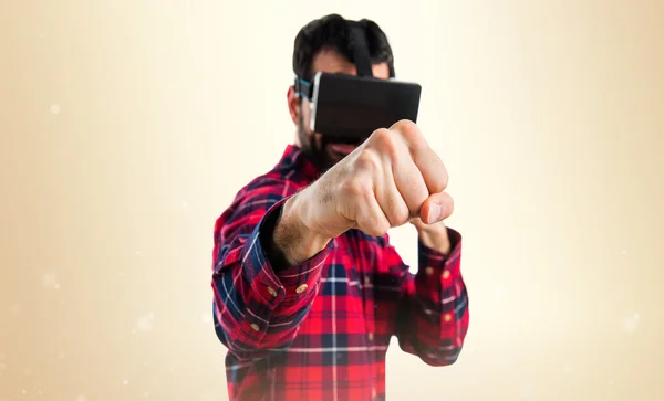 Hombre usando gafas VR dando un puñetazo —  Fotos de Stock