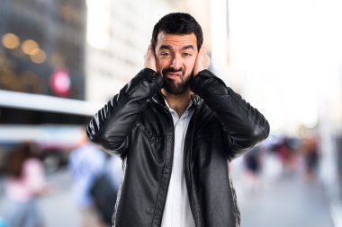 Deri ceket kulakları kapsayan adamla