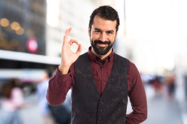 Ok işareti yapma yelek giyen adam 