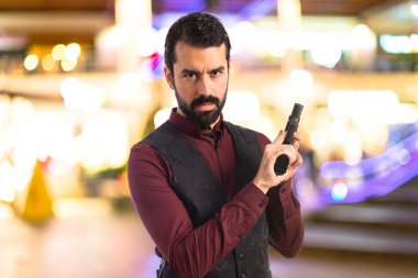 Bir tabanca ile yelek giyen adam 