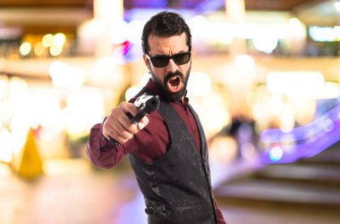 Bir tabanca ile ateş yelek giyen adam 