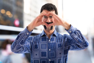 Vintage genç adam elleriyle bir kalp yapma 