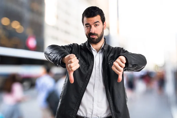 Man with leather jacket doing bad signal — Stock Photo, Image