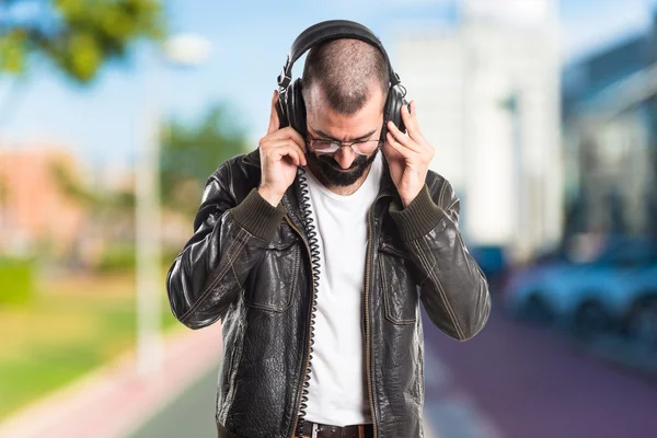 Man bär en skinn jacka lyssnar musik — Stockfoto