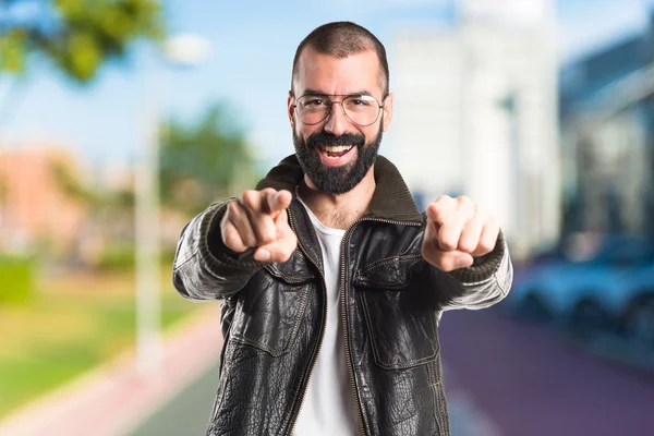 Man wearing a leather jacket pointing to the front