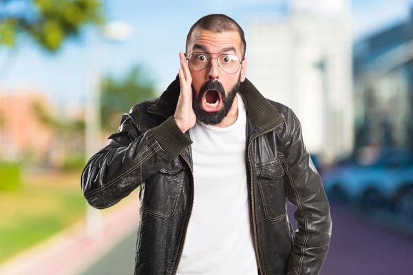 Man wearing a leather jacket doing surprise gesture — Stock Photo, Image