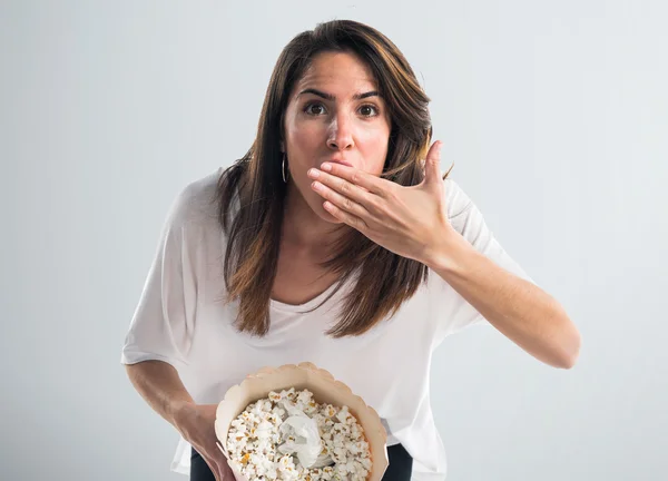 Ung flicka äter popcorns — Stockfoto
