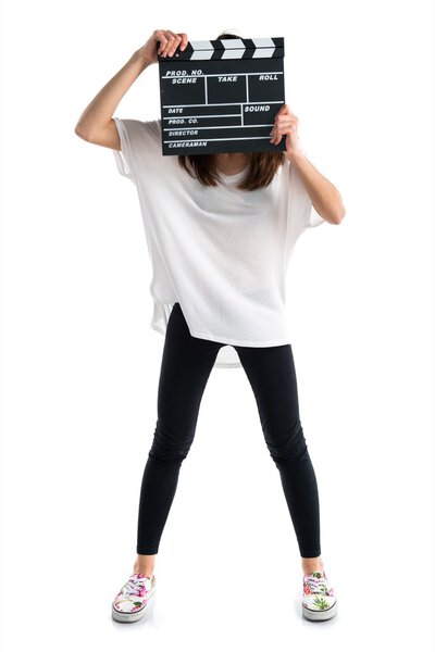 Young woman holding a clapperboard