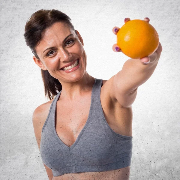 Спортивная женщина с апельсином — стоковое фото