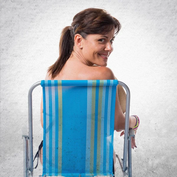 Mujer en bikini azul sentada en una silla — Foto de Stock