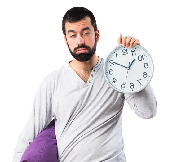 Man in pyjama's houden van klok — Stockfoto