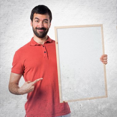 Yakışıklı adam boş bir afişini holding