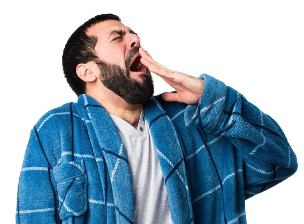 Человек в халате зевает — стоковое фото