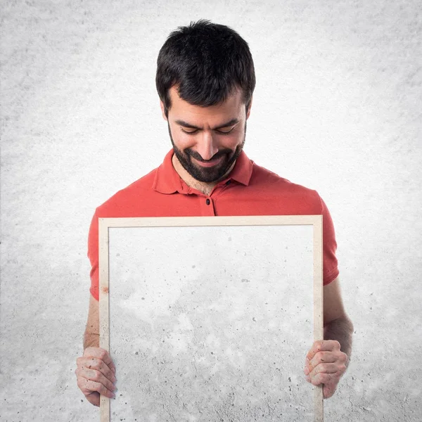 Handsome man holding an empty placard — Stock Photo, Image