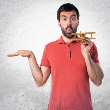 Yakışıklı adam ahşap oyuncak uçak holding