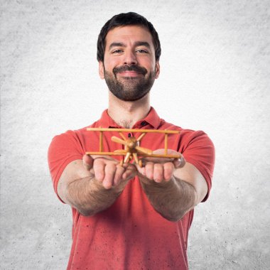 Yakışıklı adam ahşap oyuncak uçak holding