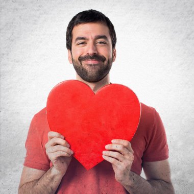 Bir kalp simgesi olan yakışıklı adam