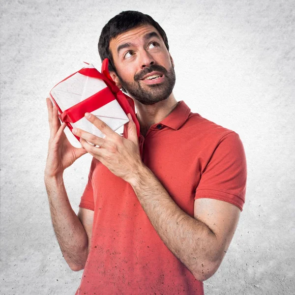 Handsome man holding a gift — Stock Photo, Image